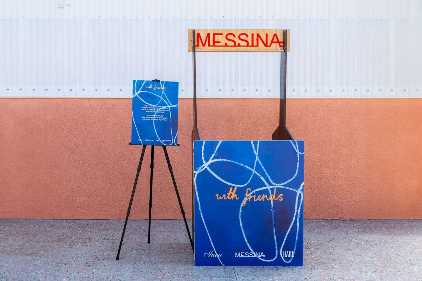 Small gelato stand with a blue hand-drawn panel and a matching A2 menu on an easel