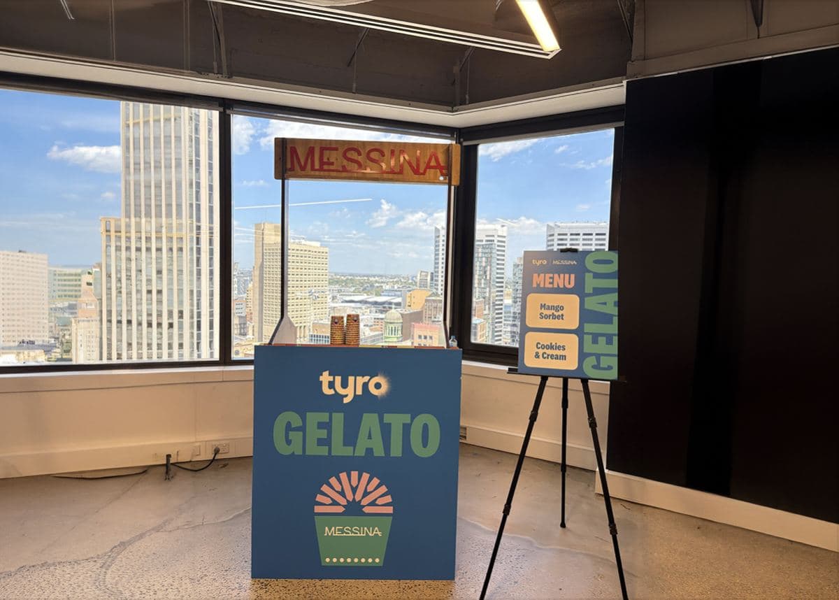 Small gelato stand in an office with a green Tyro Gelato panel and menu